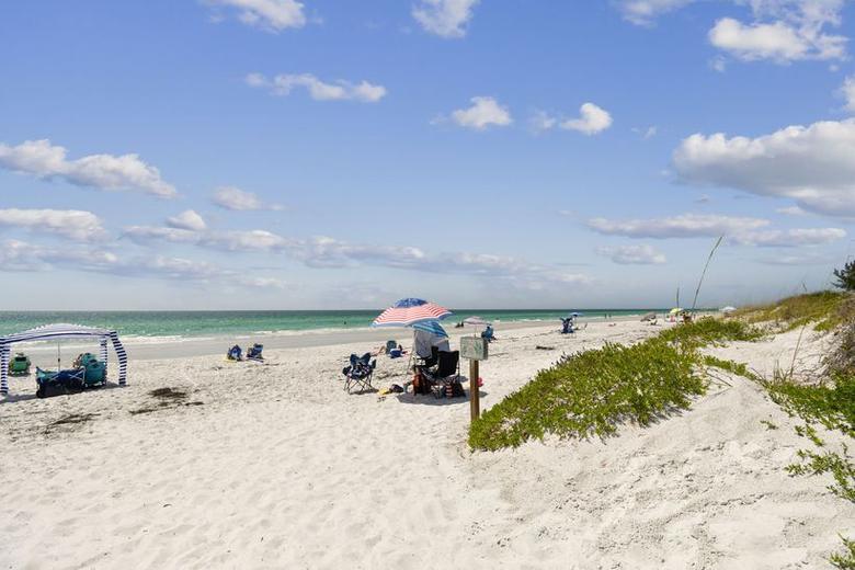 Sand dunes and sea oats between the building and the beach