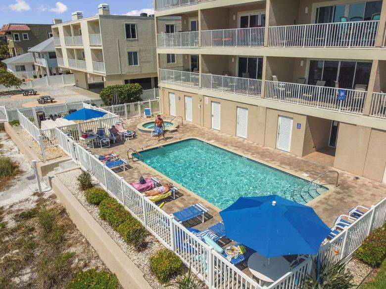 The heated pool and hot tub at Oceanside, with loungers and umbrellas