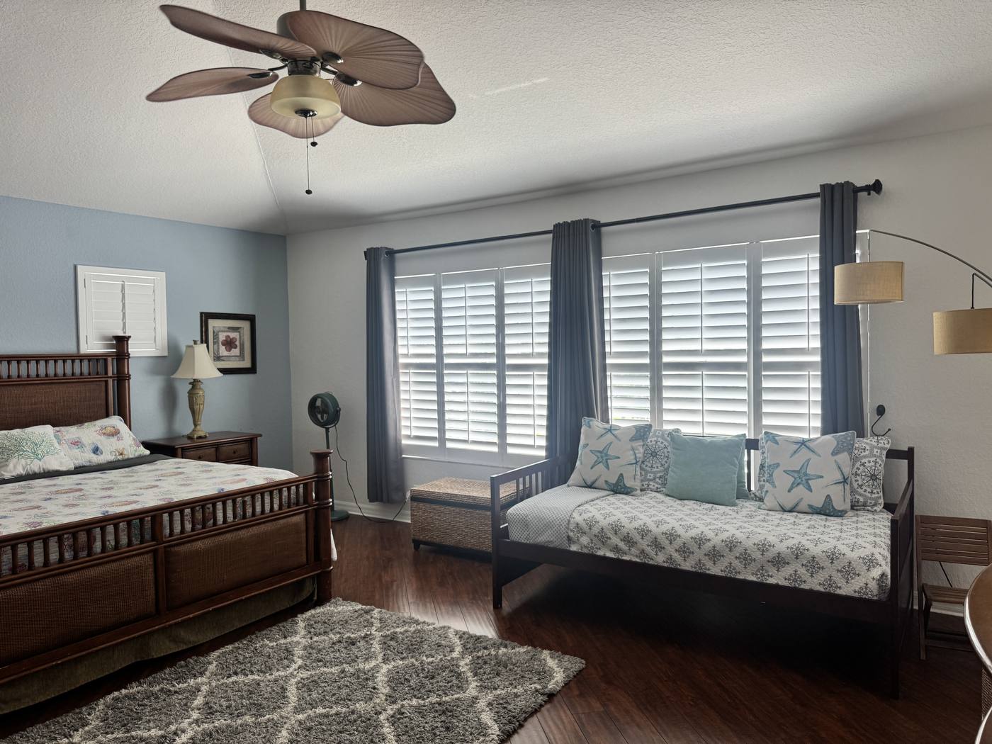 The primary bedroom's daybed and window seat beside plantation-shuttered windows