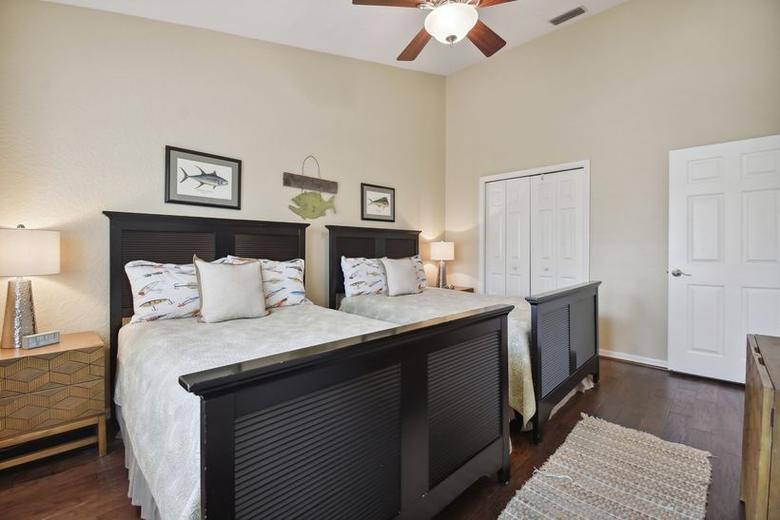 Second bedroom with two beds and dark wood headboards