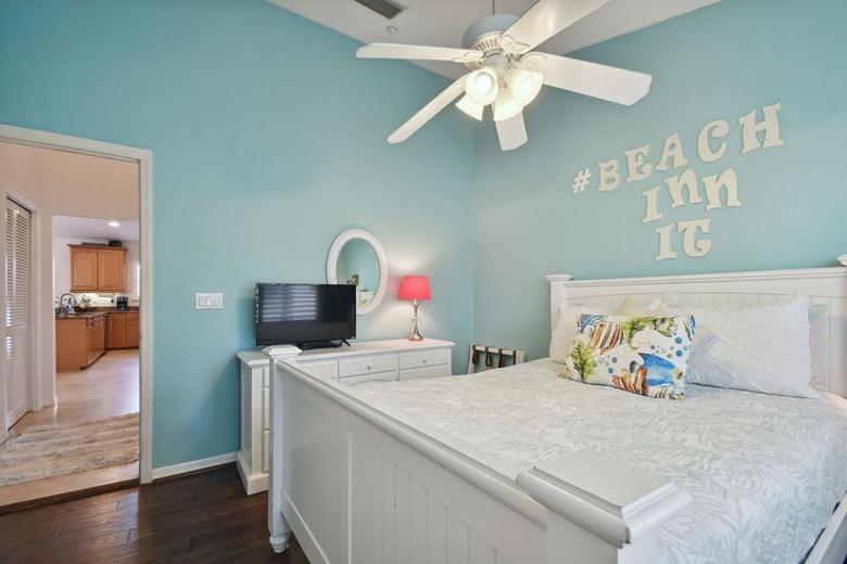Third bedroom painted seafoam with #BeachInnIt letters on the wall